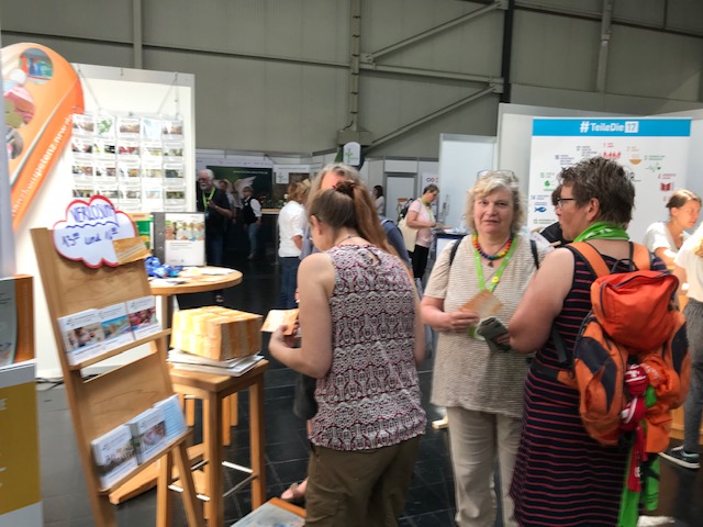 Messestand mit Besuchern. Foto: NUA